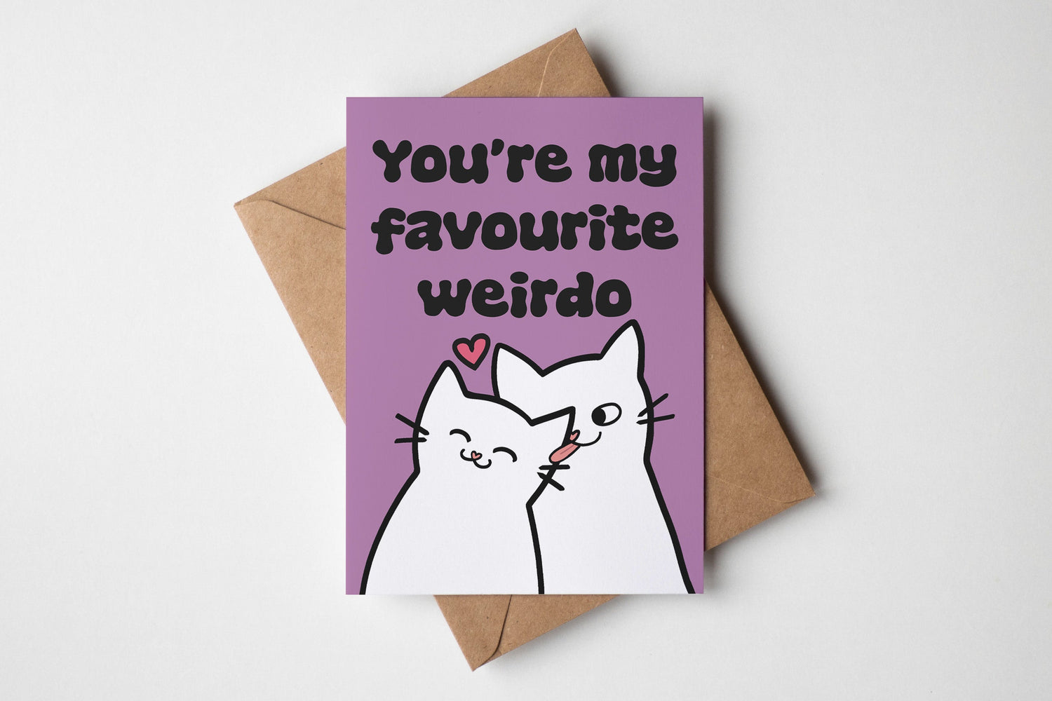 Card with a cat illustration and text 'You're my favourite weirdo' on a purple background with a brown envelope.