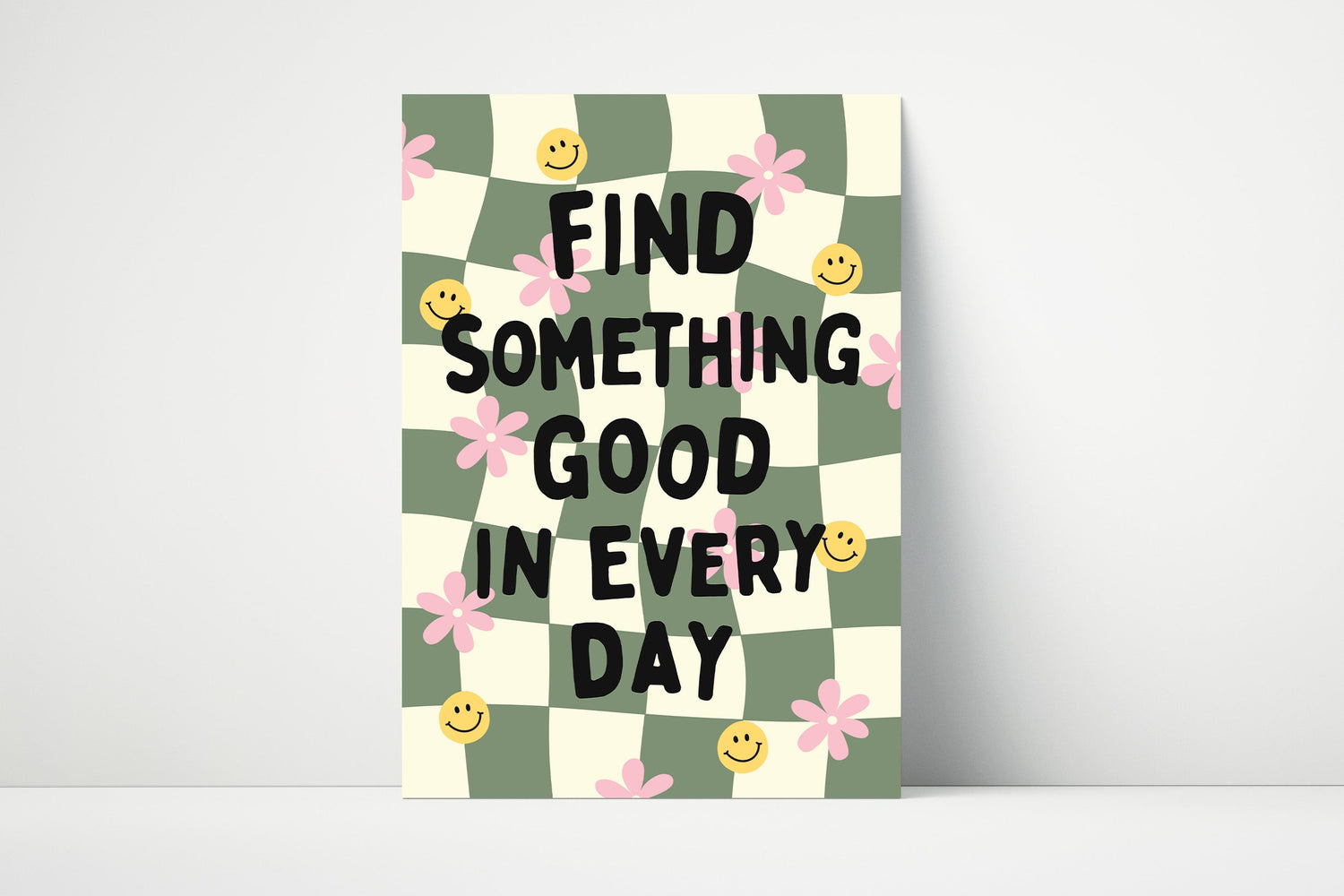 Green checkered print with smiley faces and flowers with the phrase "Find something good in every day".