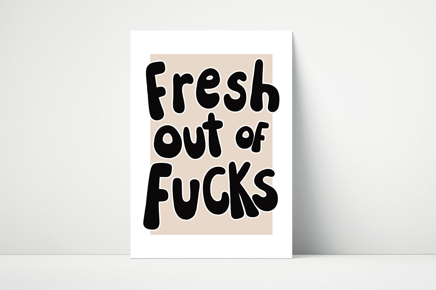 Bold handwritten text print with the phrase "Fresh Out of Fucks" on a beige background.