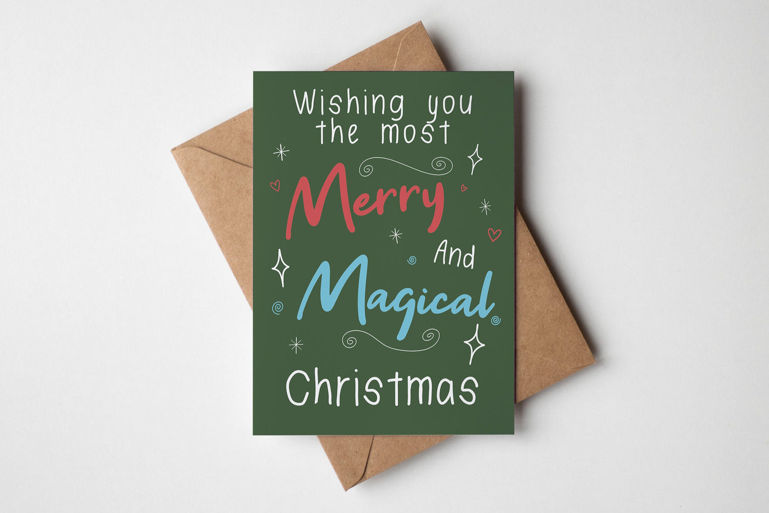 Christmas card with 'Wishing you the most Merry and Magical Christmas' text on a green background with a brown envelope.