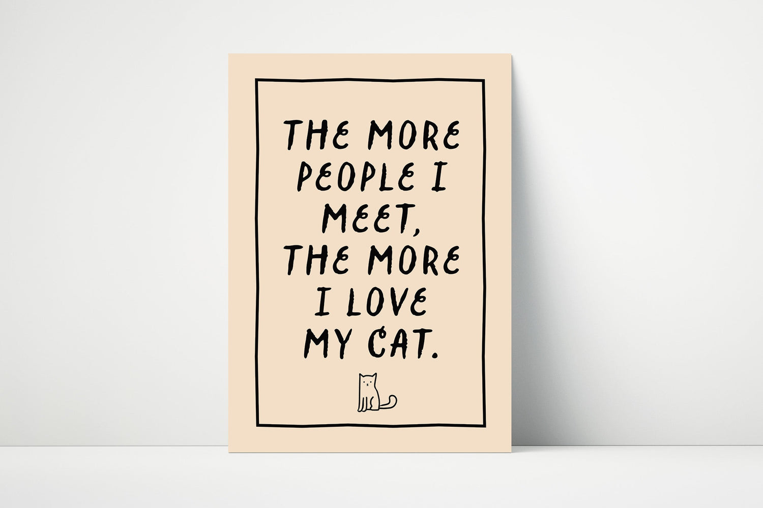 Typography wall art print that says "the more people I meet, the more I love my cat." in bold text printed on matte paper.