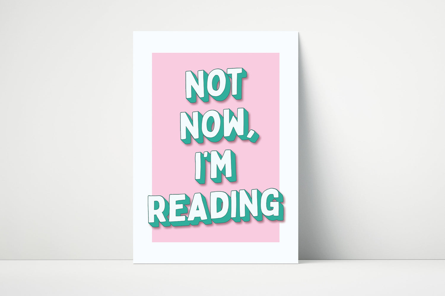 Wall art print with the phrase “Not Now I’m Reading” in bold typography, ideal for reading nooks and book lover décor.