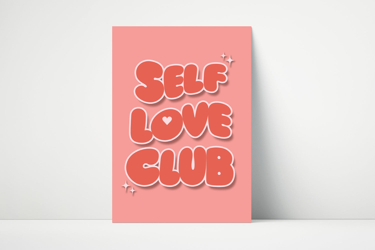 Typography wall art that says "Self Love Club" with bold red bubble letters on a pink background.