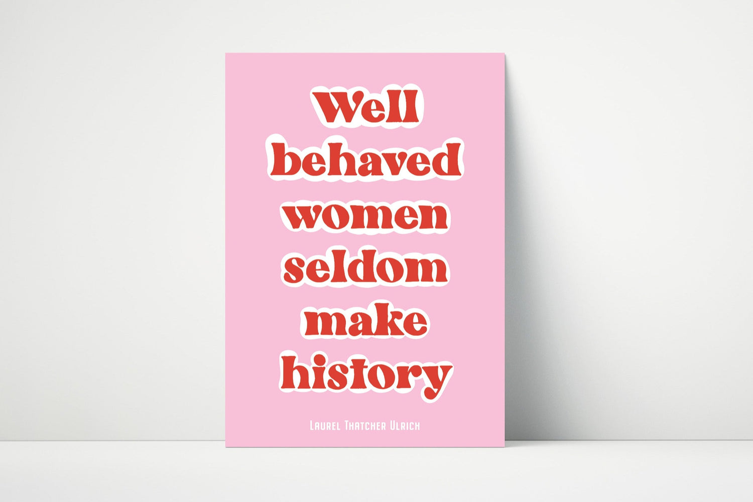 A pink poster with white text that reads 'Well behaved women seldom make history', in bold, inspirational typography.